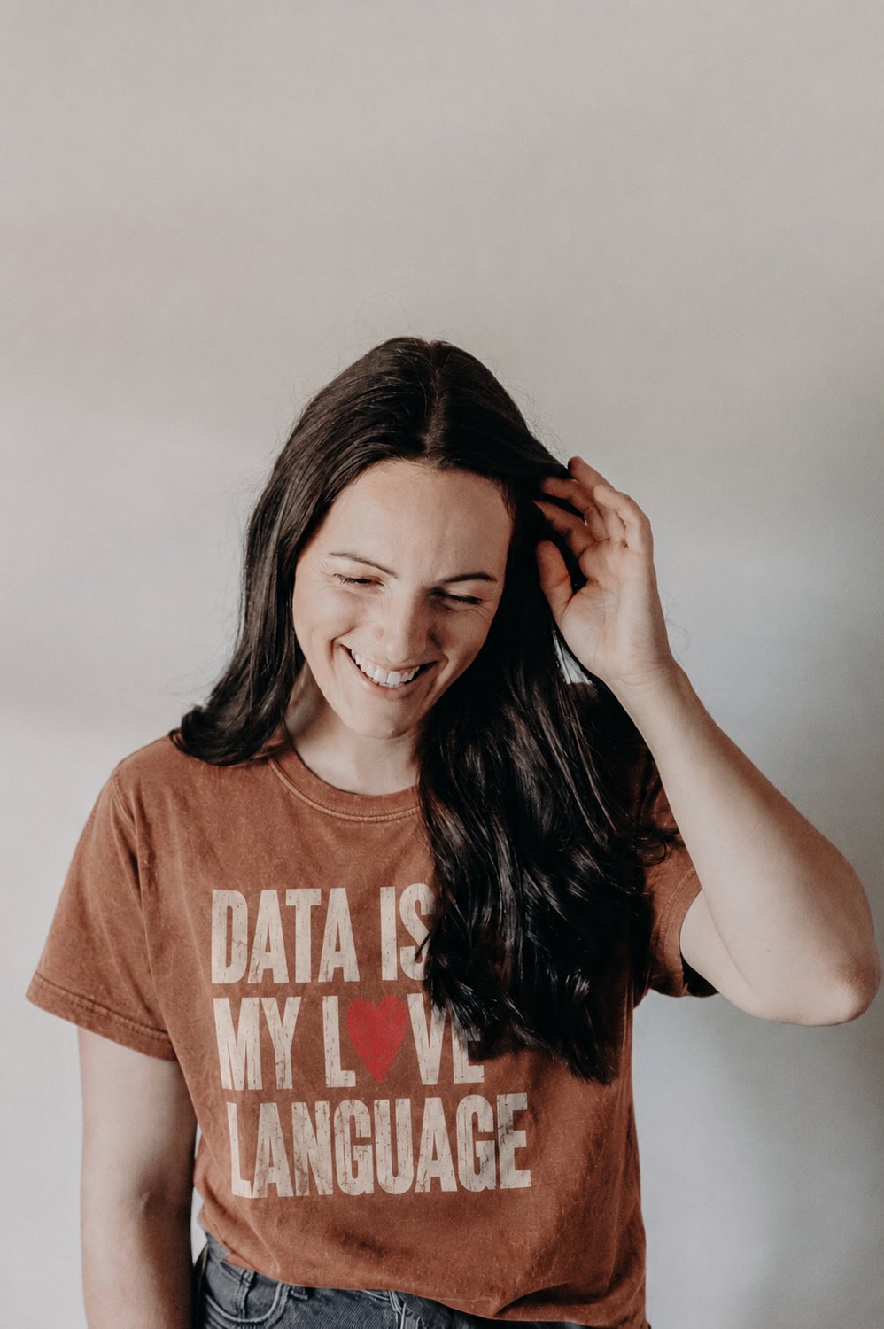 Ash Topham laughing, wearing a t-shirt that reads: data is my love language